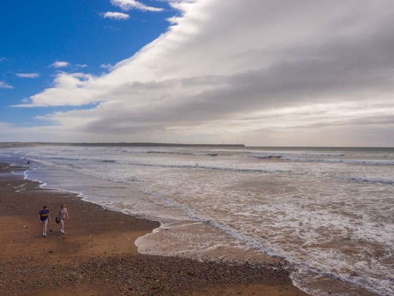 Ein Mann und eine Frau gehen am Strand entlang