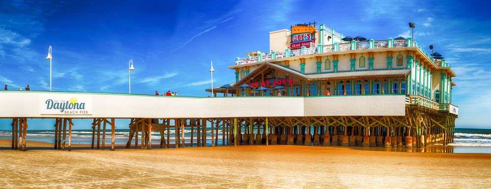 A daytona beach pier with a sign that says daytona beach pier