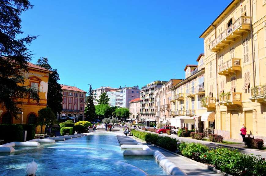 Eine Reihe von Gebäuden mit einem Brunnen im Vordergrund