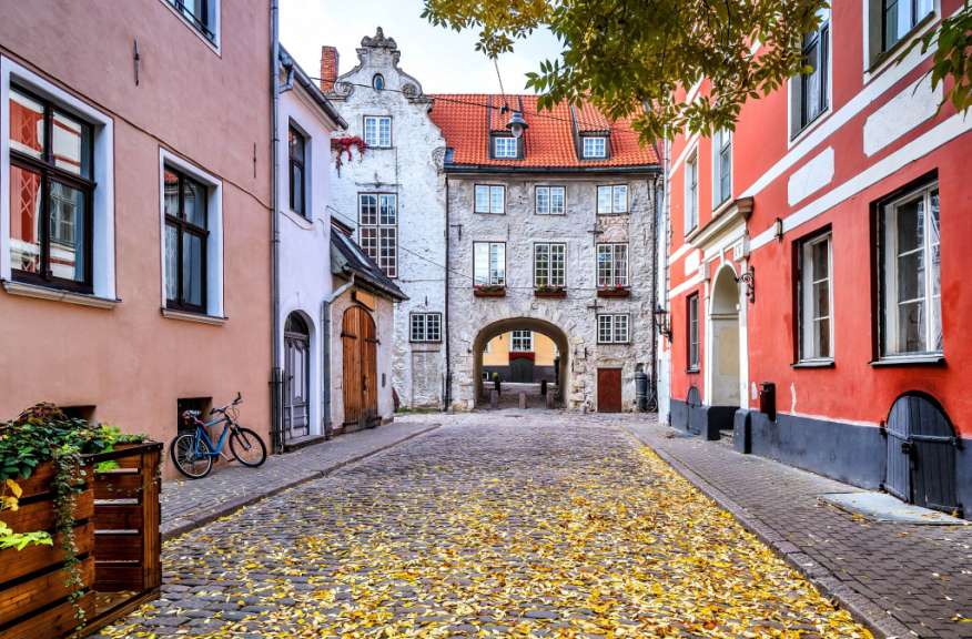Ein blaues Fahrrad steht auf einer gepflasterten Straße zwischen zwei Gebäuden