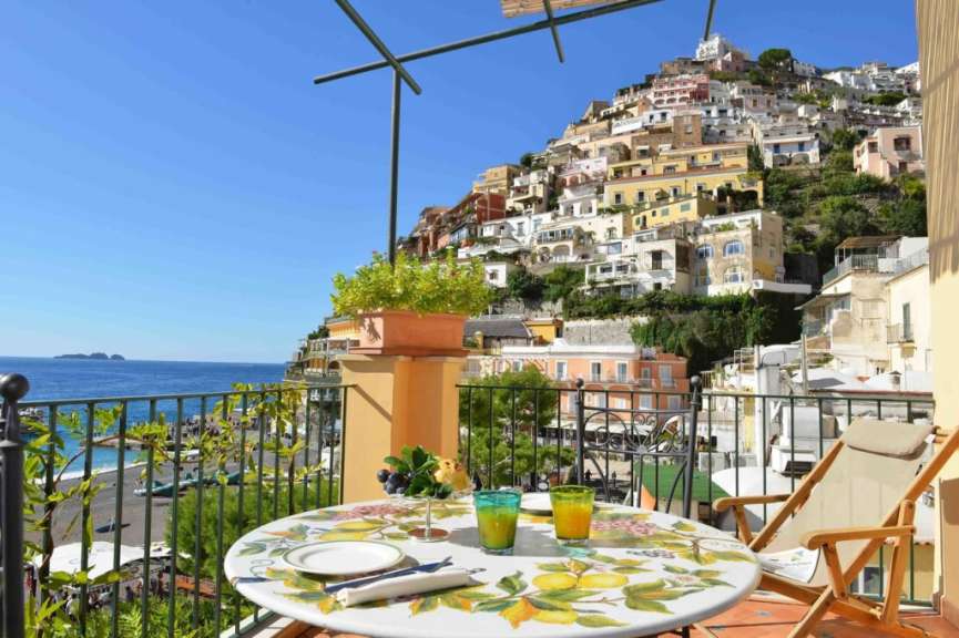 Ein Balkon mit einem Tisch und Stühlen und einem Blick auf eine Stadt