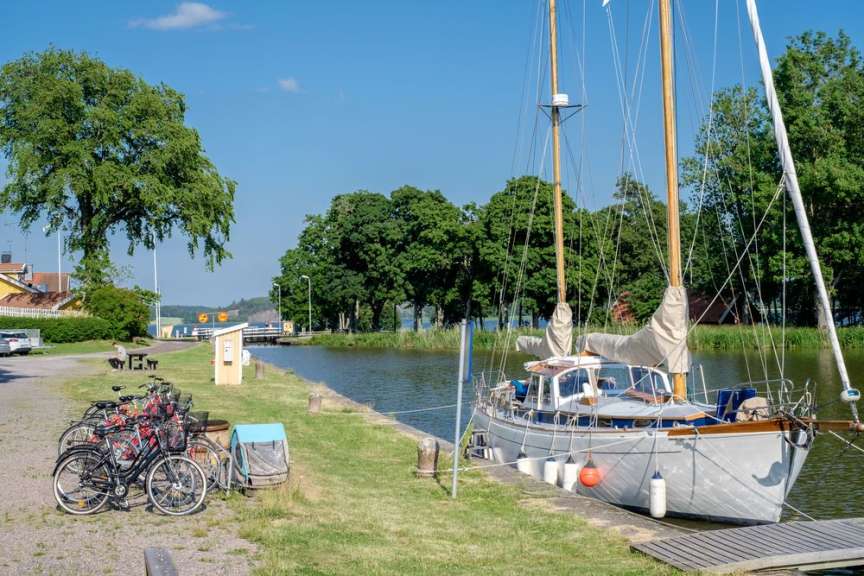 Eine Reihe von Fahrrädern steht neben einem Segelboot