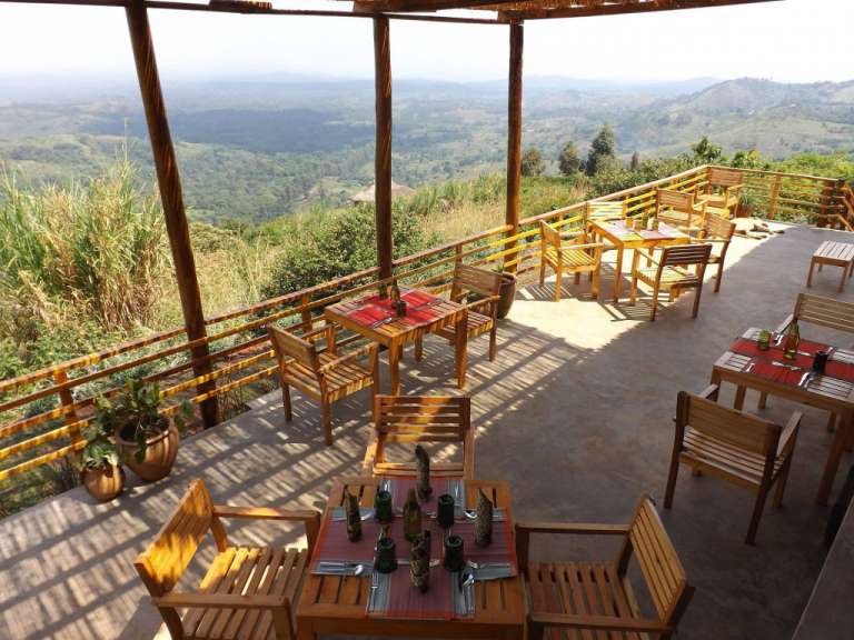 Tische und Stühle auf einer Terrasse mit Blick auf die Berge