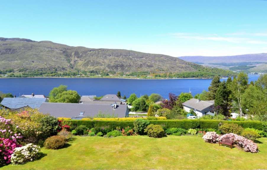 Ein Garten mit Blick auf einen See mit Bergen im Hintergrund