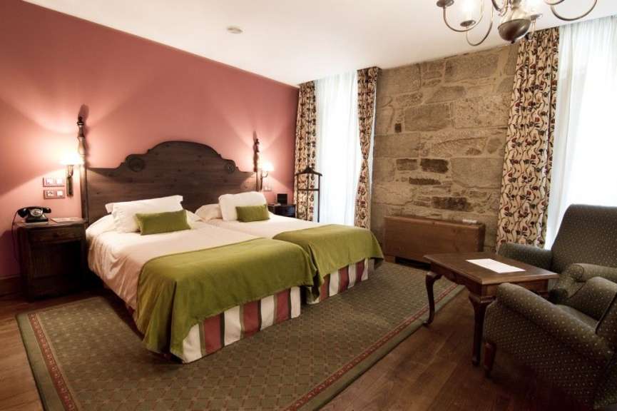 Ein Hotelzimmer mit zwei Betten und einem Stuhl