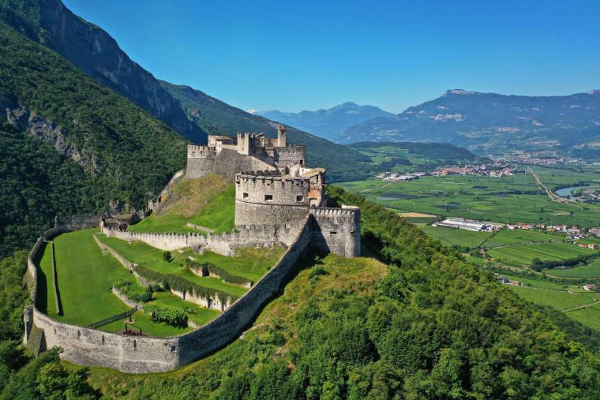 Eine Burg sitzt auf einem Hügel inmitten einer grünen Landschaft
