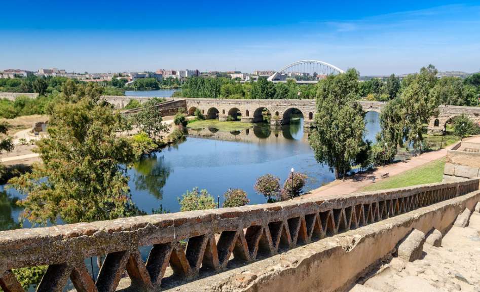Eine Brücke über einen Fluss mit Bäumen im Vordergrund