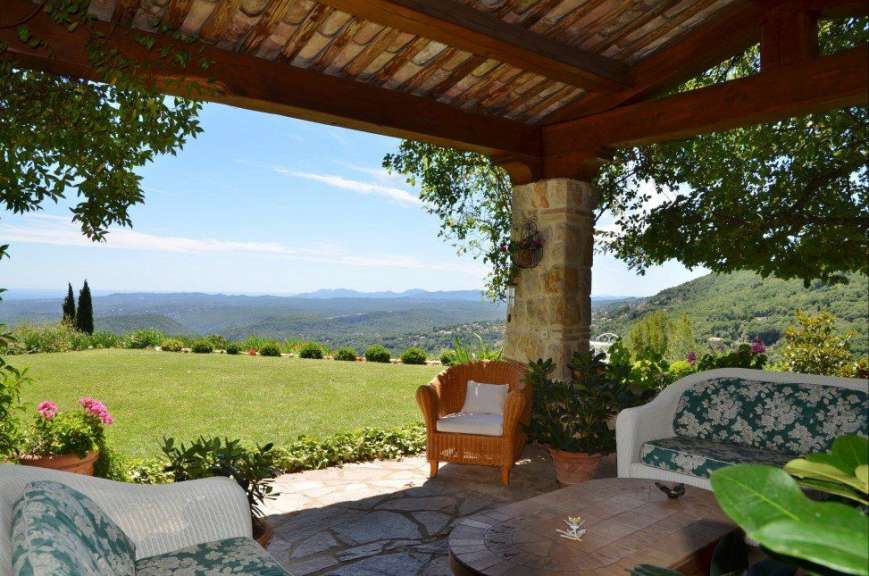 Eine Terrasse mit Möbeln und einem Tisch mit Blick auf die Berge