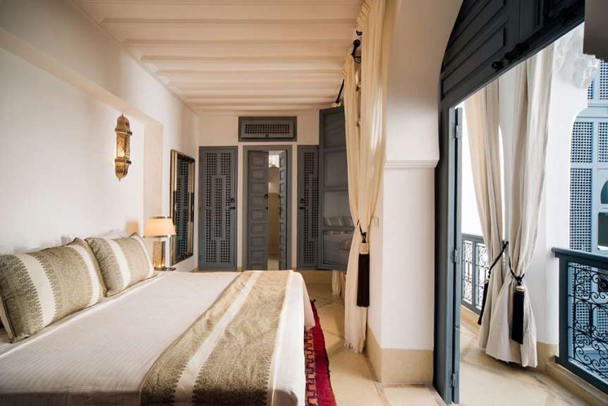 Ein Schlafzimmer mit einem großen Bett und einem Balkon
