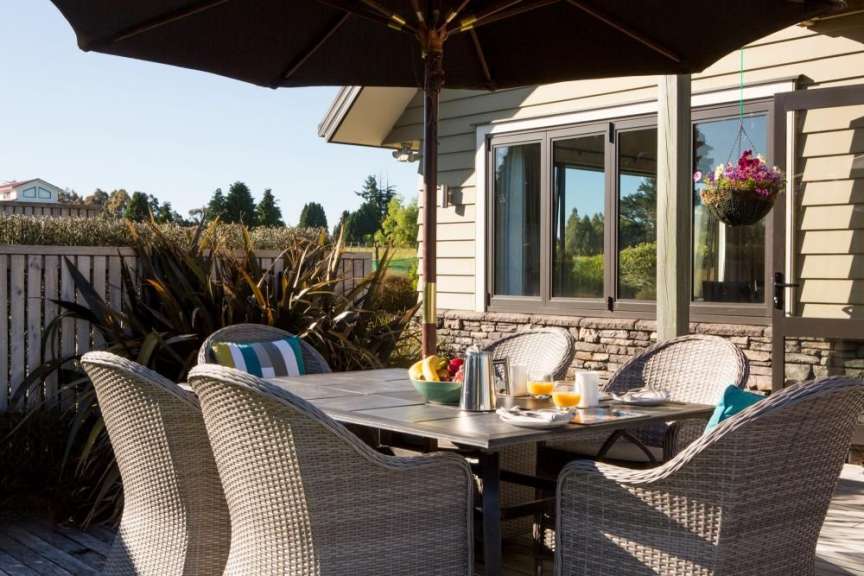 Eine Terrasse mit Tisch und Stühlen und einem Sonnenschirm