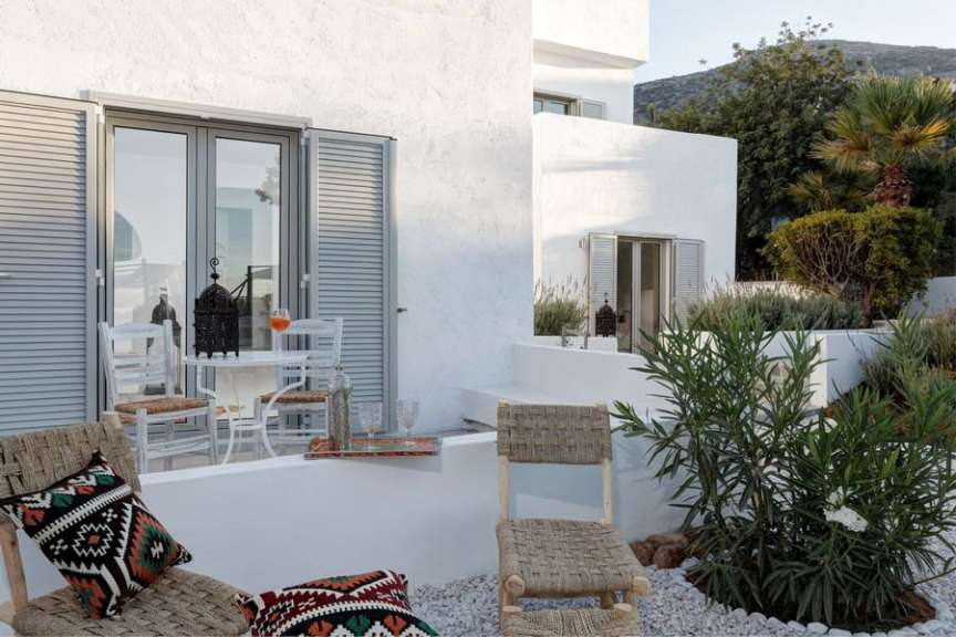 Ein weißes Haus mit einem Tisch und Stühlen davor