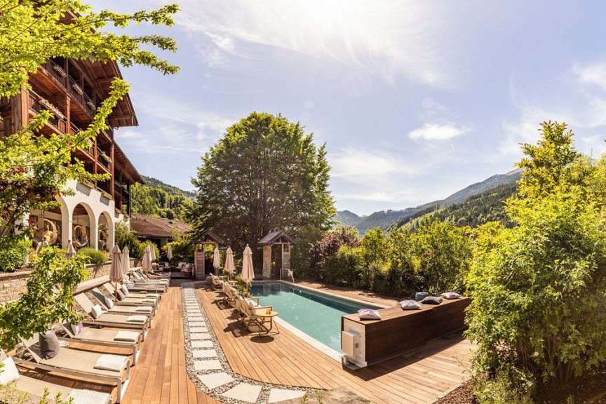 Ein luxuriöses Hotel mit Pool und Liegestühlen in den Bergen.