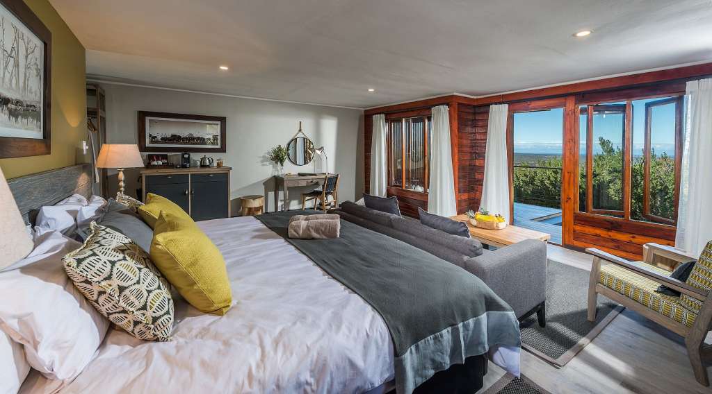 Ein Schlafzimmer mit einem großen Bett und vielen Fenstern