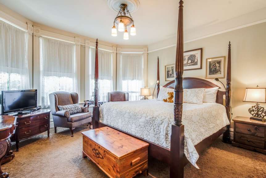 Ein Schlafzimmer mit einem Himmelbett und einem Fernseher