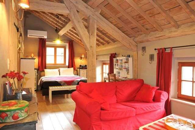 Ein Wohnzimmer mit einem roten Sofa und einem Bett