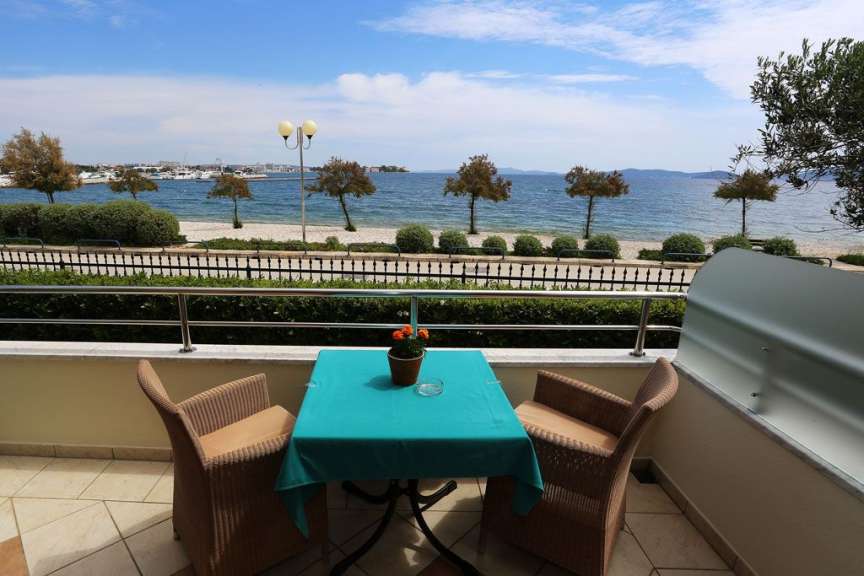 Ein Tisch und Stühle auf einem Balkon mit Blick auf das Meer