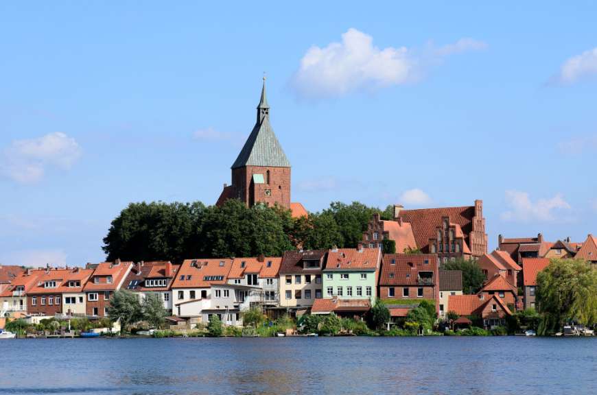 Eine Stadt mit einer Kirche auf einem Hügel über einem See
