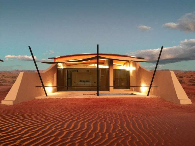 Eine moderne Unterkunft inmitten einer Wüstenlandschaft, mit einer beeindruckenden Architektur, die sich in die Umgebung einfügt.