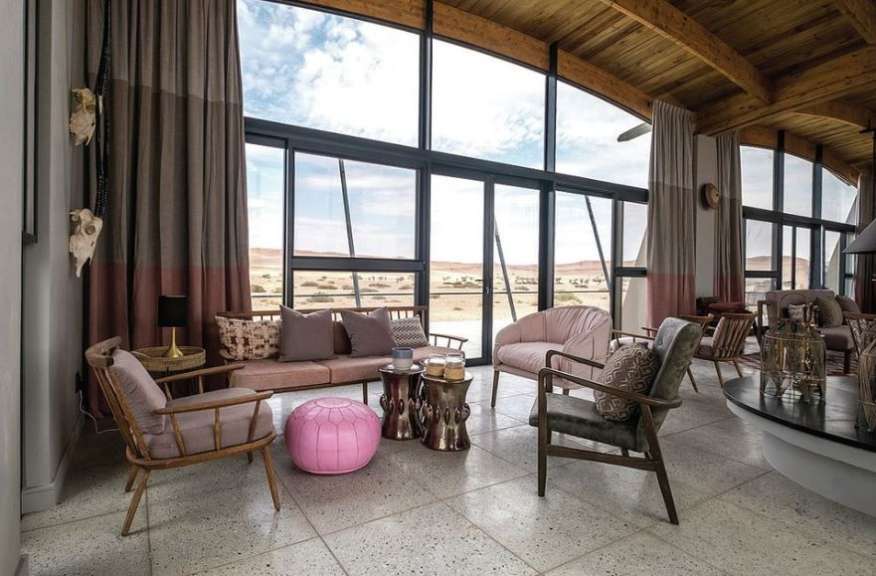 Ein stilvolles Wohnzimmer mit großen Fenstern bietet einen atemberaubenden Blick auf die Wüstenlandschaft.