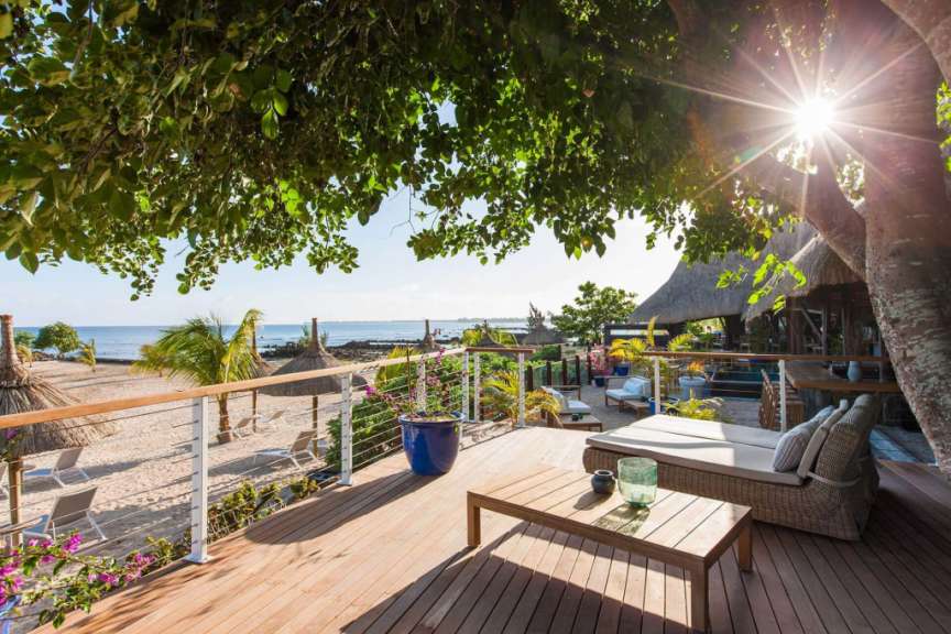 Die Sonne scheint durch die Bäume auf einem Holzdeck