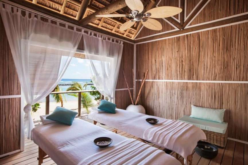 Ein Zimmer mit zwei massagetischen und einem Deckenventilator