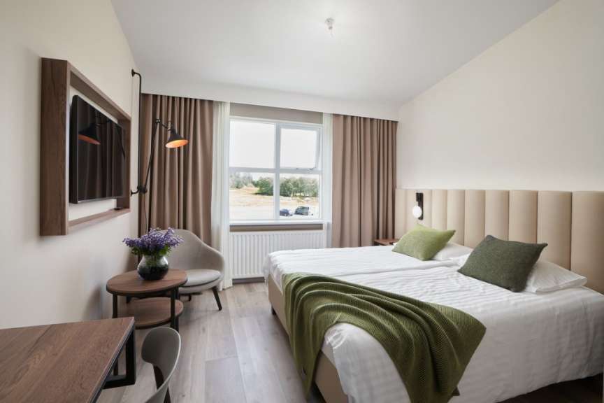 Ein Hotelzimmer mit zwei Betten und einem Fernseher