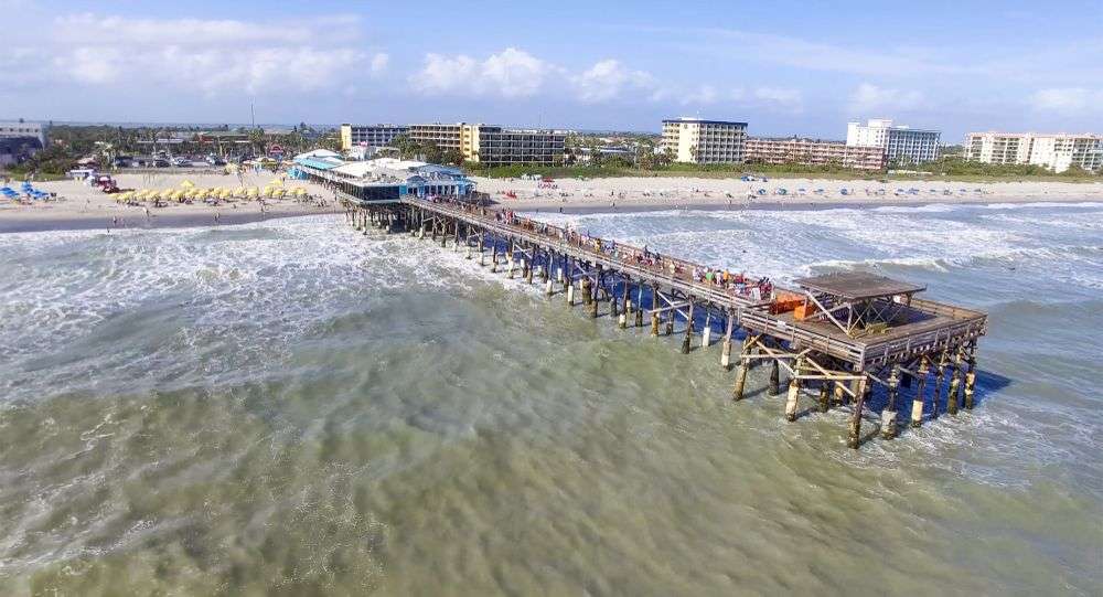 Eine Gruppe von Menschen steht an einem Pier in der Nähe eines Strandes