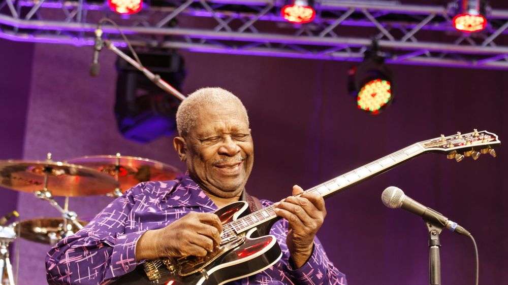 Ein Mann spielt eine gibson-Gitarre auf einer Bühne