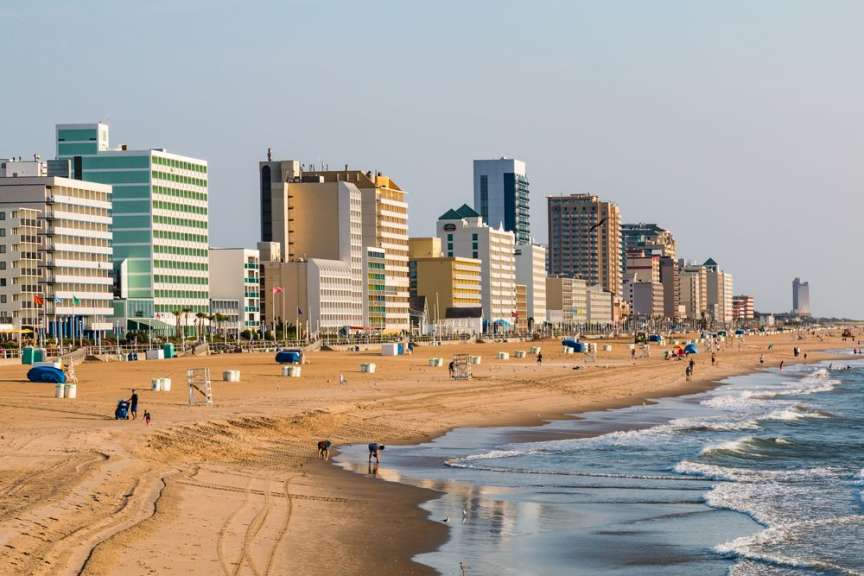 Ein Strand mit Menschen und Hochhäusern im Hintergrund.