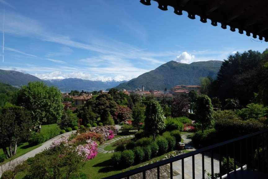 Ein Balkon mit Blick auf einen Garten mit Bergen im Hintergrund