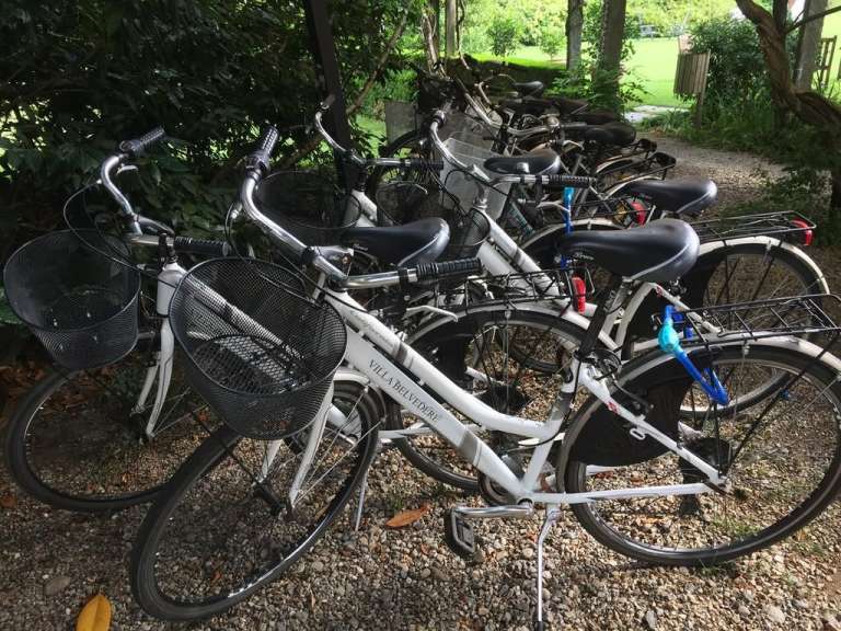 Eine Reihe von weißen fahrrädern mit körben steht nebeneinander
