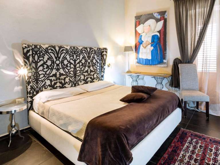 Ein Schlafzimmer mit einem Bett und einem Gemälde an der Wand