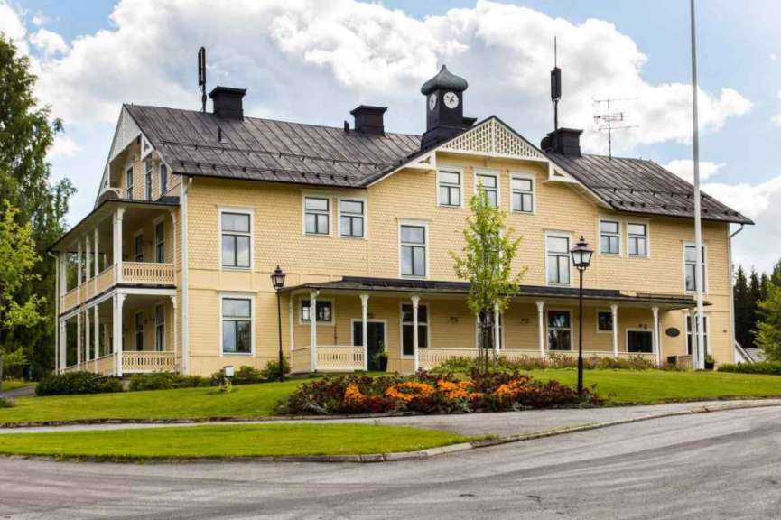 Ein großes gelbes Haus mit einer Uhr auf dem Dach