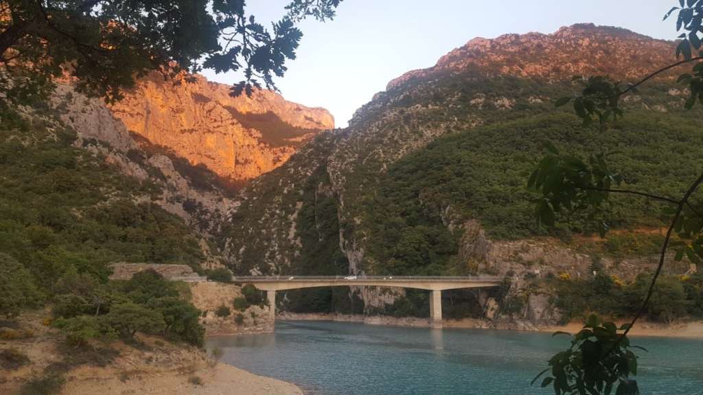 Eine Brücke über einen See mit Bergen im Hintergrund