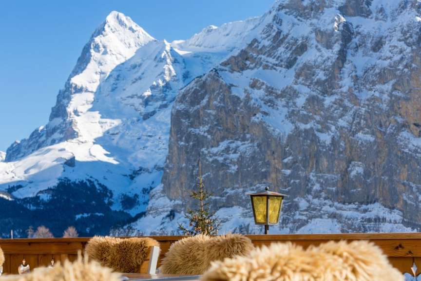 Eine hölzerne Terrasse mit Blick auf schneebedeckte Berge