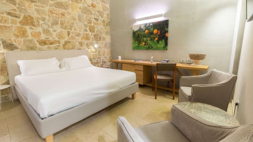 Ein Hotelzimmer mit einem Bett, einem Schreibtisch und zwei Sesseln.