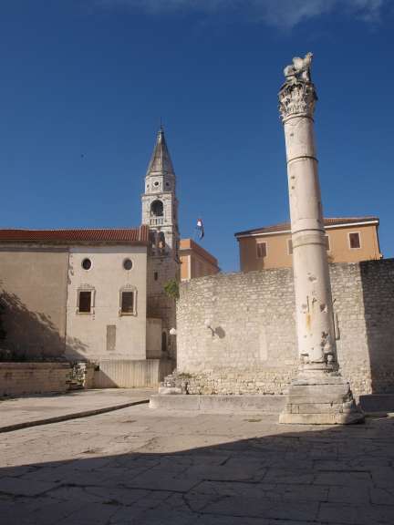 Eine Statue eines Löwen auf einem Säulen vor einem Gebäude
