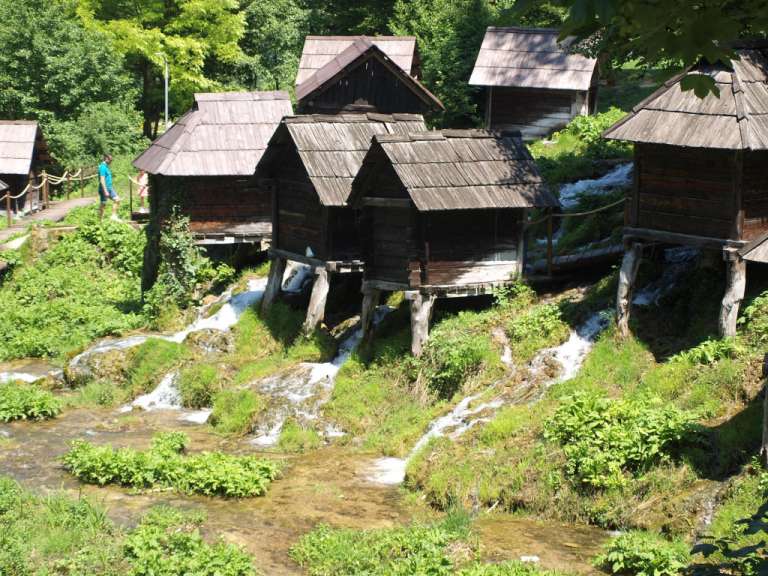 Eine Gruppe von Holzhütten neben einem Wasserfall