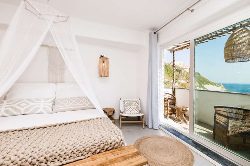 Ein weißes Schlafzimmer mit einem Bett und einem Stuhl