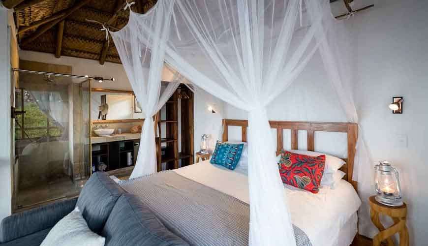 Ein Schlafzimmer mit Himmelbett, Couch und Dusche .