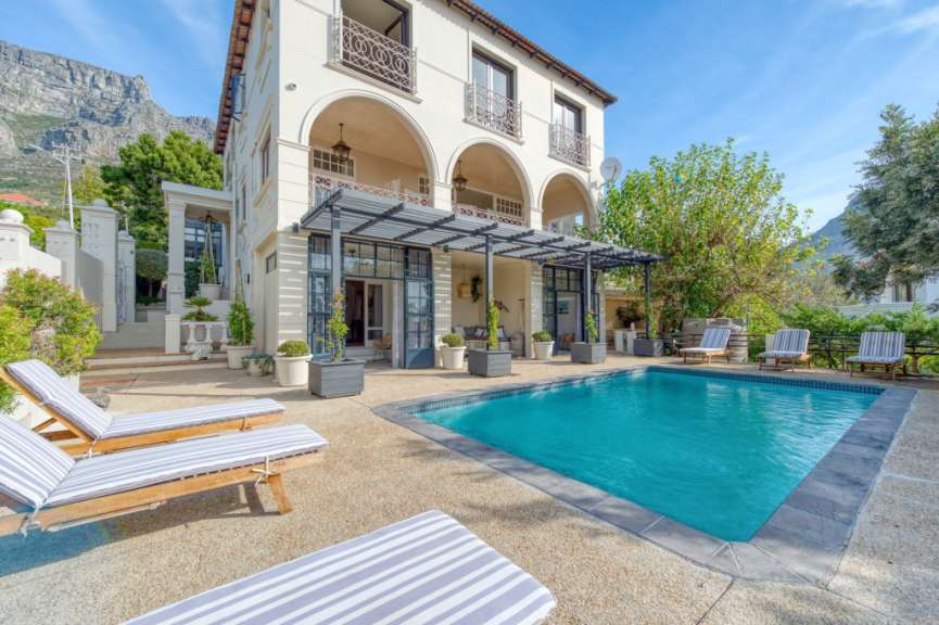 Ein großes weißes Haus mit einem großen Swimmingpool davor