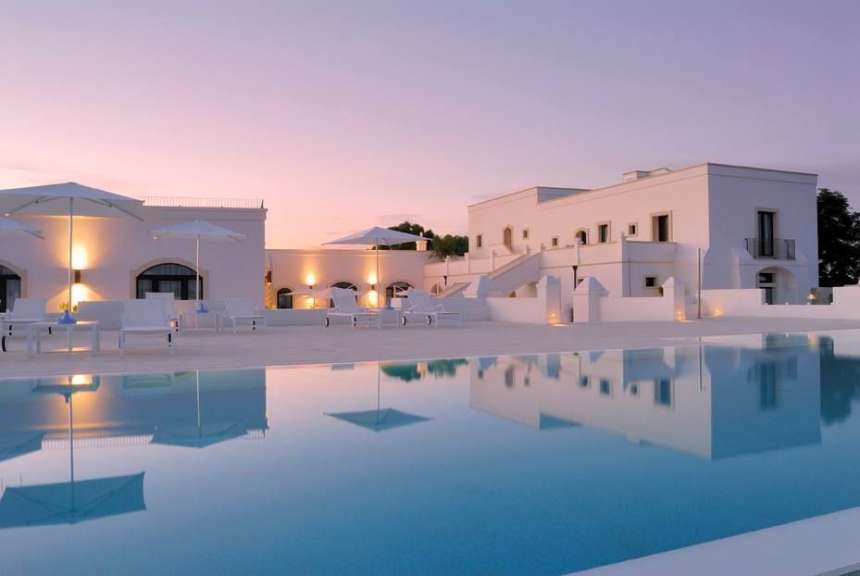 Ein weißes Gebäude mit einem großen Pool davor