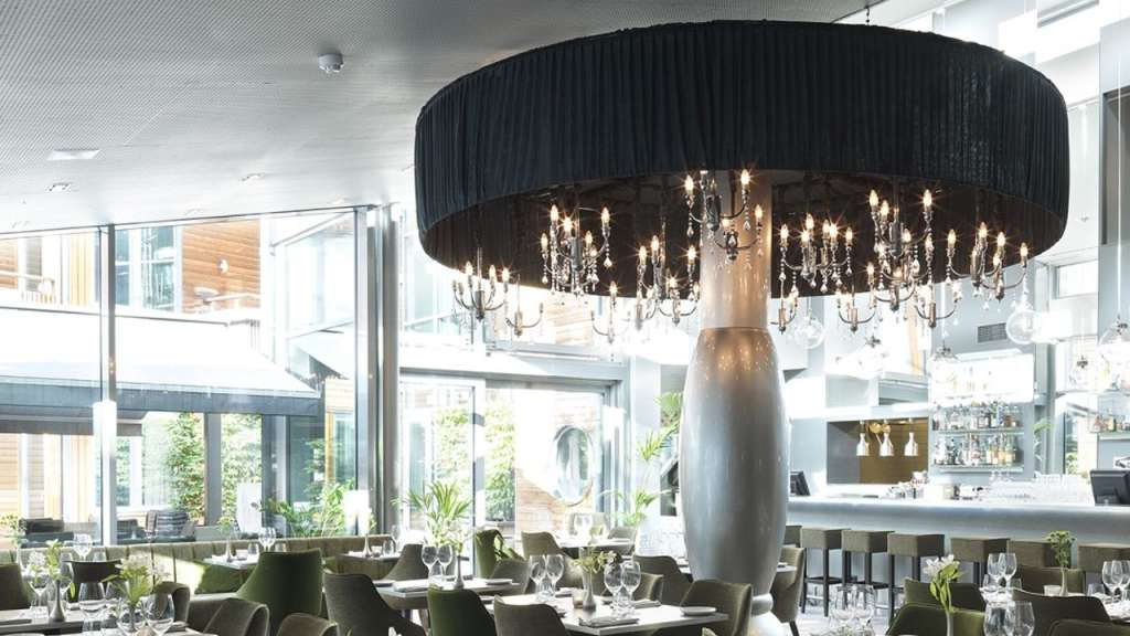 Ein Restaurant mit vielen Tischen und Stühlen und einem großen Kronleuchter