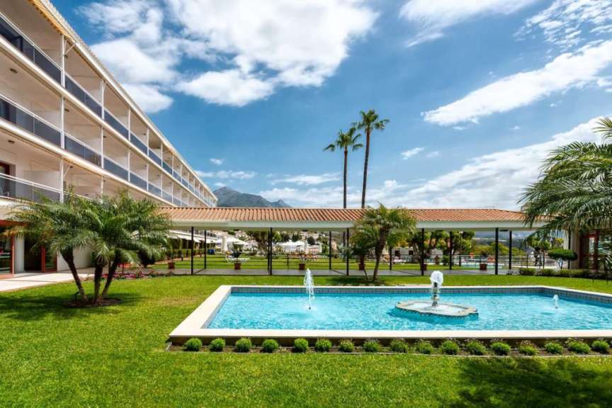 Ein großes Hotel mit einem Pool und einem Brunnen