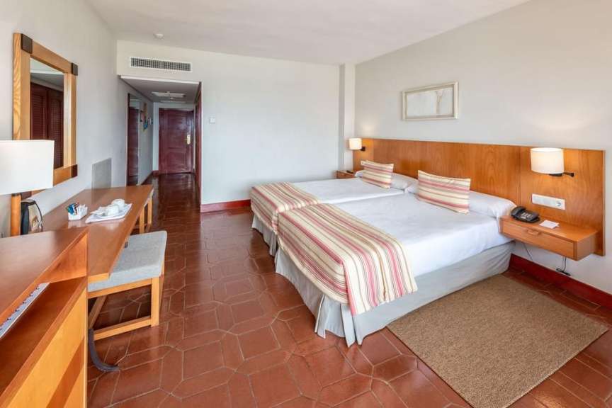 Ein Hotelzimmer mit zwei Betten und einem Schreibtisch