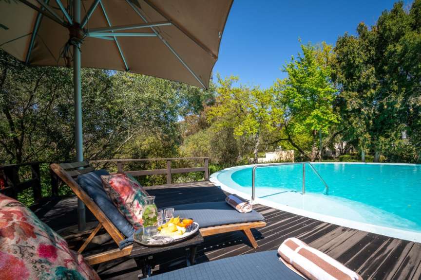 Liegestühle auf einem Deck neben einem Swimmingpool