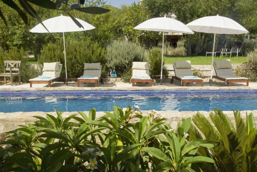 Liegestühle und Sonnenschirme um einen Swimmingpool