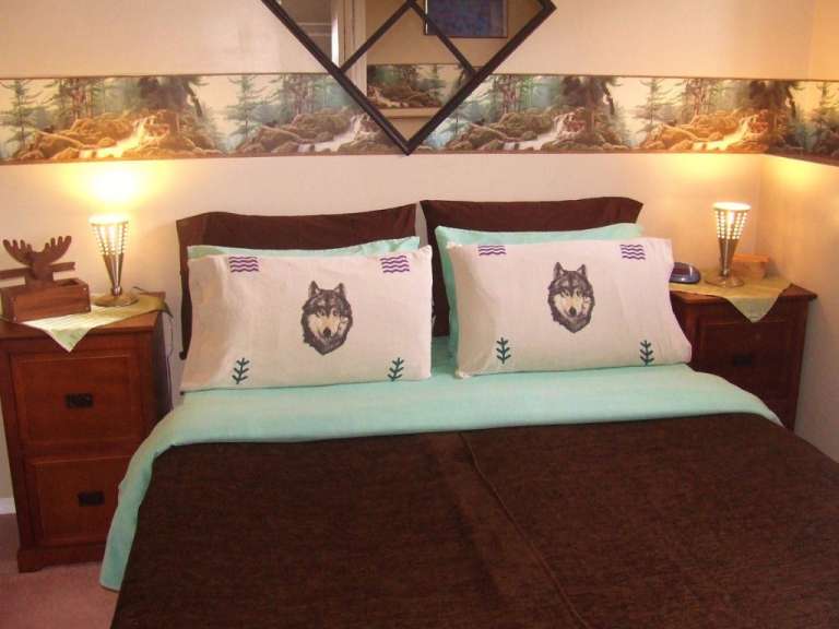 Ein Bett mit zwei Kissen mit einem Wolfskopf darauf