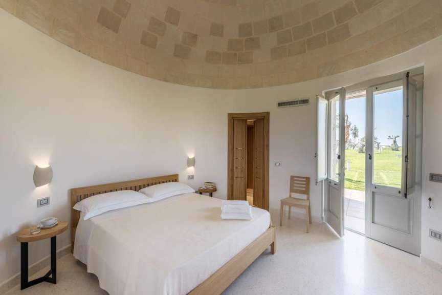 Ein weißes Schlafzimmer mit einem Bett und einem Stuhl