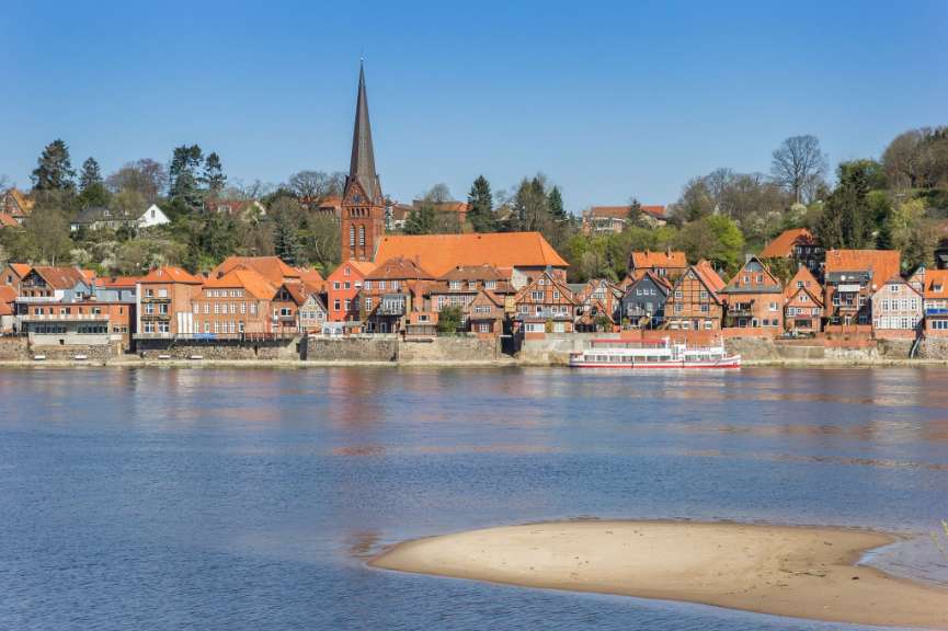 Eine Ansicht von Lüneburg, Deutschland, von der Elbe aus, mit traditionellen Häusern und einem Kirchturm.